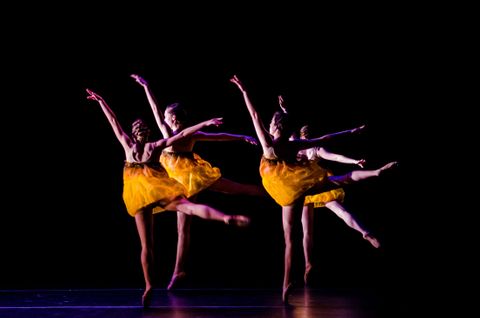 Four dancers en pointe with gold dresses. The dancers represent lanterns floating down a river.