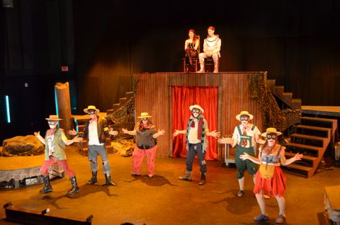 A wide view of the stage for Dionysus of the Holocaust during a performance. This is during one of the minstrel portions of the show. The scene was given a warm look and used footlights to give it an olde time, gas-lit theatre feel.