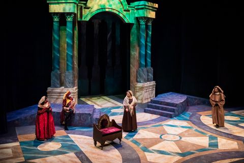 Set for Measure for Measure with curved ramps and several sets of columns upstage.