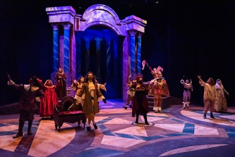 Another wide view of the set for Measure for Measure during a performance this time showing the upstage column silhouettes.